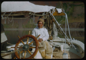 Image of Eskimo [Inuk] man with glasses, at wheel