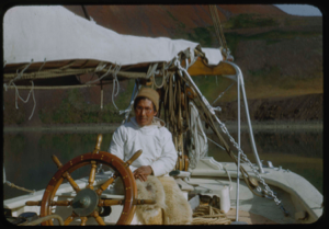 Image of Eskimo [Inuk] man with glasses, at wheel