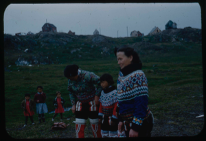 Image of Eskimo [Inuit] women and child in traditional dress; other children beyond