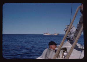 Image of Two-masted Portuguese fishing vessel; Donald  MacMillan [?] on The Bowdoin in foreground
