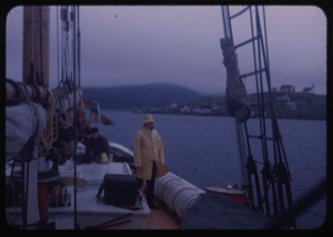 Image of Donald MacMillan on deck, in slicker. First view of Labrador