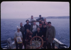Image of Crew posed by wheel; with Miriam MacMillan
