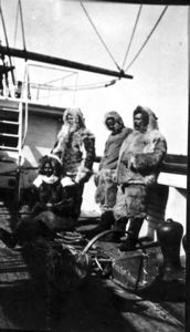 Image of Matthew Henson, Donald MacMillan, George Borup, and Tom Gushue in furs, aboard SS Roosevelt