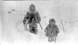 Image: Inuit father with saw and a child, in snow wearing furs