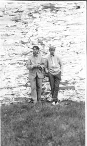 Image of Two men (crew?) against stone wall
