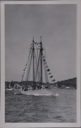 Image of Schooner BOWDOIN at Boothbay Harbor, dressed and under way; guests aboard