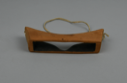 Image of Carved wooden goggles with large rectangular eye slit; held on by one soft thong