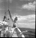 Image of Crewman watching iceberg with binoculars  at Battle Harbor