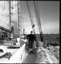 Image of Icebergs through rigging; Donald MacMillan on deck