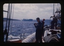 Image of Bill Powers on deck. Iceberg beyond.