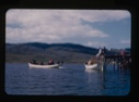Image of boatload of Eskimos [Inuit] approaching dock