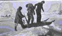 Image of 2 Eskimo [Inuit] men (one carrying child) and white man on sledge across small lead
