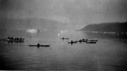 Image of Eskimos [Inuit] in an open boat, and 7 kayakers