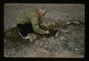 Image of Close up view of Count Knuth investigating Eskimo [Inuit] tent ring at Centrum Lake