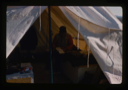 Image of Davies USGS completing field notes in sleeping tent at Polaris Promontory Site.