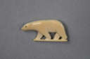 Image of Polar bear. Black eye, carved mouth. Bear is standing on small piece (clasp carv