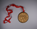 Image of medal from the Dutch Treat club, on red ribbon