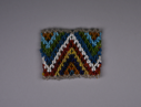 Image of Child's beaded cuff in clear, orange, blue, yellow, red, white, green jagged pat