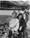 Image of Donald MacMillan in foul weather gear with Miriam MacMillan at wheel