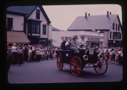 Image of Old fashioned car and passengers in parade