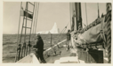 Image of Crewmen on deck, iceberg beyond