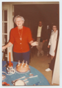 Image of Miriam MacMillan admiring her birthday cake