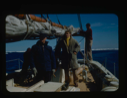 Image of Donald MacMillan and crewmen on the Bowdoin. Ice pack beyond.