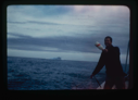 Image of Ian White throwing bottle with a record overboard. (2 copies)