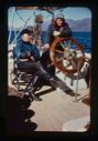 Image of Miriam MacMillan at wheel, Donald sitting by. (2 copies)