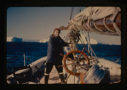 Image of Miriam MacMillan at wheel. Icebergs beyond (2 copies)