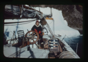 Image of Miriam MacMillan at wheel. Iceberg beyond. (2 copies)