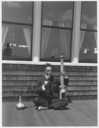 Image of Man seated cross legged on porch with Turkish pipe