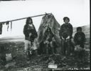 Image of Family standing by tupik. Meat drying on rack