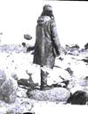 Image of Man (back to) wearing long coat with hood, Nascopie style hat