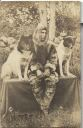 Image of Postcard: Unsmiling man in arctic dress with 2 dogs on table