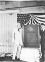 Image of Adolphus Greely and Donald MacMillan standing by Greely tablet readied for trans