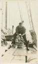 Image of Richard Goddard on deck, standing on crates of supplies