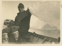 Image of Donald Mac Millan in small boat (Elto engine) holding iceberg corner