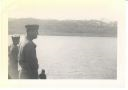 Image of Two men looking out from ship, a third man below