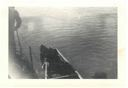 Image of Serviceman in canoe along-side ship