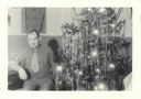 Image of Serviceman sitting by Christmas tree