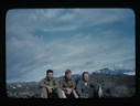 Image of Three officers sitting on rocky landscape