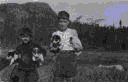Image of Eskimo [Inuk] boy and William Thomas, jr., each holds two puppies