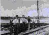 Image of Crewmen carrying large hose by railroad track