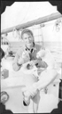 Image of Seated crewman holding two stuffed seal pups