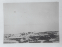 Image of Rocky, snowy foreground. Looking across ice to hills  