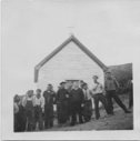 Image of Group of Innu in front of church at the encampment [Father J. Cyr, Joe Rich and others]