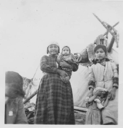 Image of Innu mothers and children by tent [Shenish Pasteen (foreground), Manishan (Mary Jane) Pasteen, Shanut (Janet) Pasteen, Tshmish (James) Pasteen, Miniskuess Pasteen]