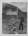 Image of David Nutt at Hebron cairn with U.S. flag