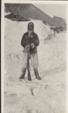 Image of Expedition man in furs, with rifle, by Borup Lodge. (Jot Small)